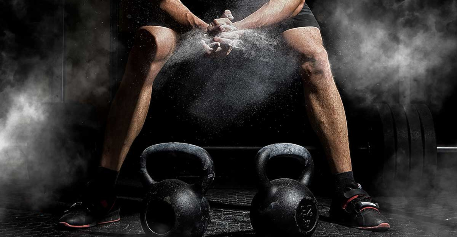 Foto di un atlea in procinto di alzare una coppia di kettle bell.